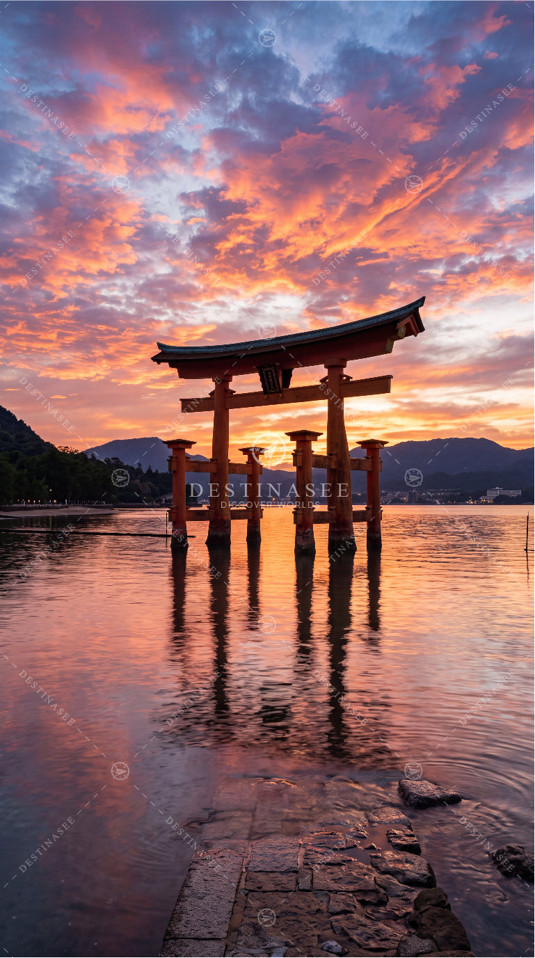 Mobile wallpaper with red torii gate over calm lake at orange-pink sunset