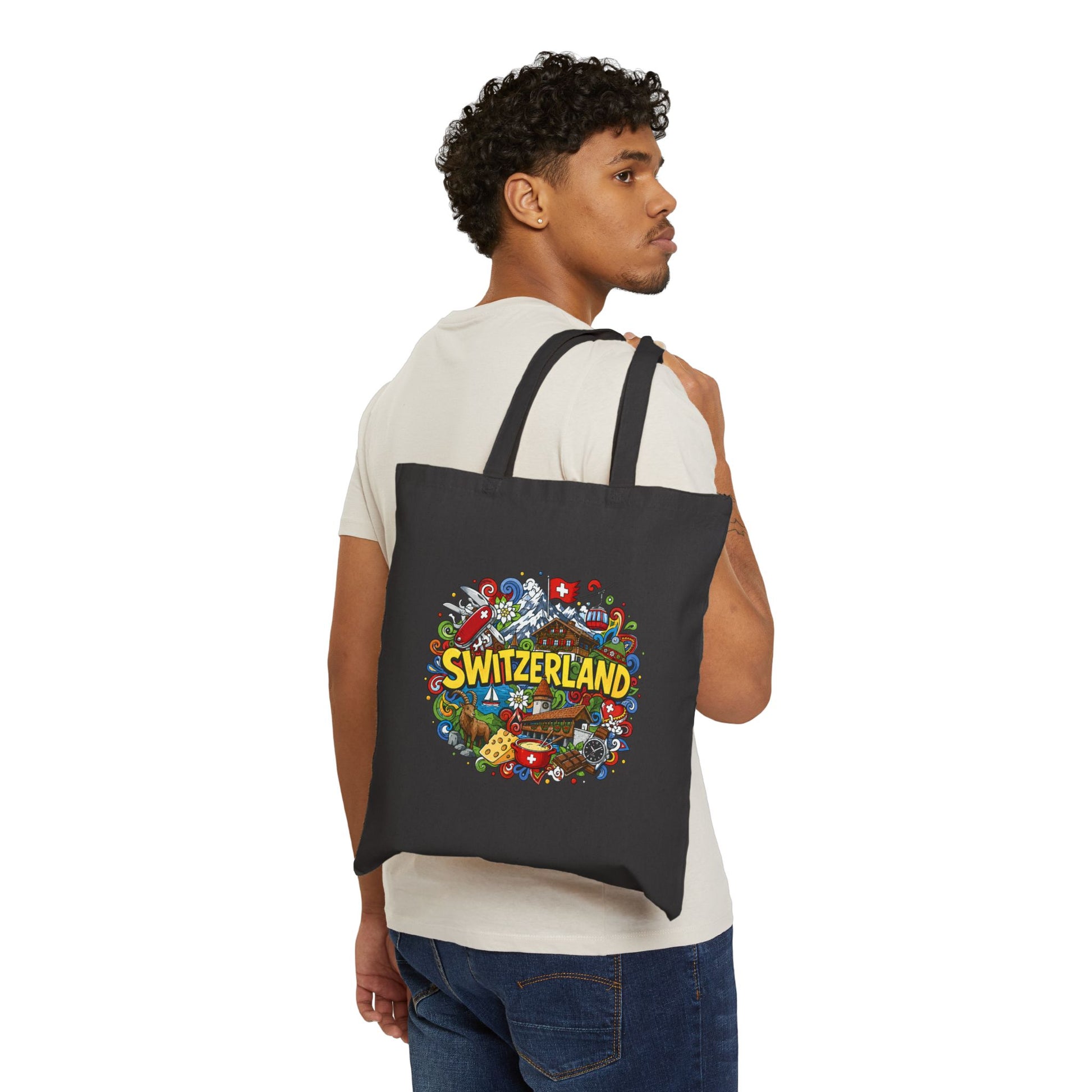 Black canvas tote bag worn on back, with Switzerland graphic on the front
