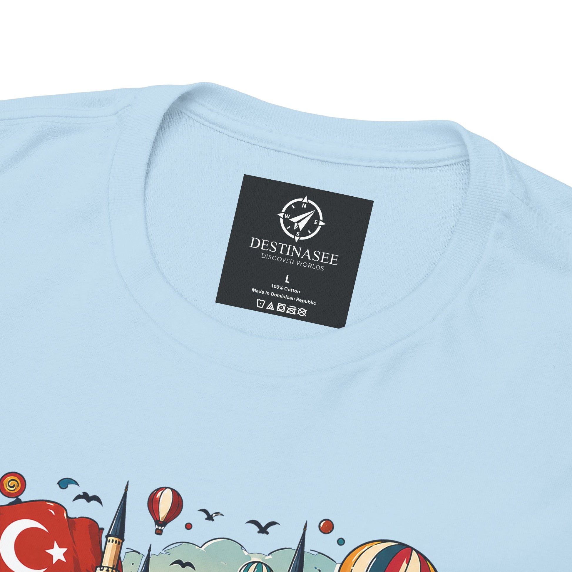 Light blue graphic tee with small neck label and partial bottom graphic detail