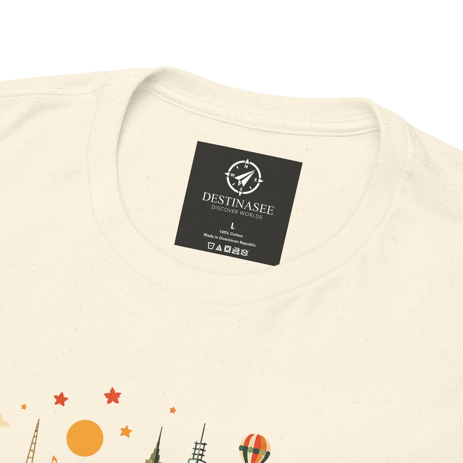 Cream T-shirt back neck shows a black square logo patch above the graphic