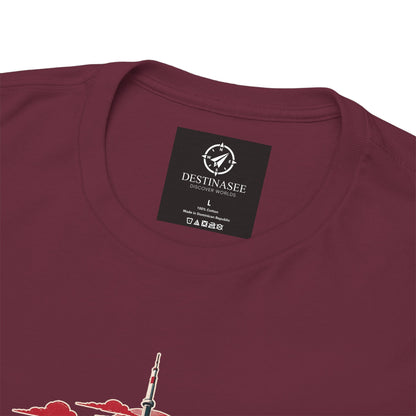 Maroon T-shirt close-up: Destinasee collar label and partial red/teal city skyline print
