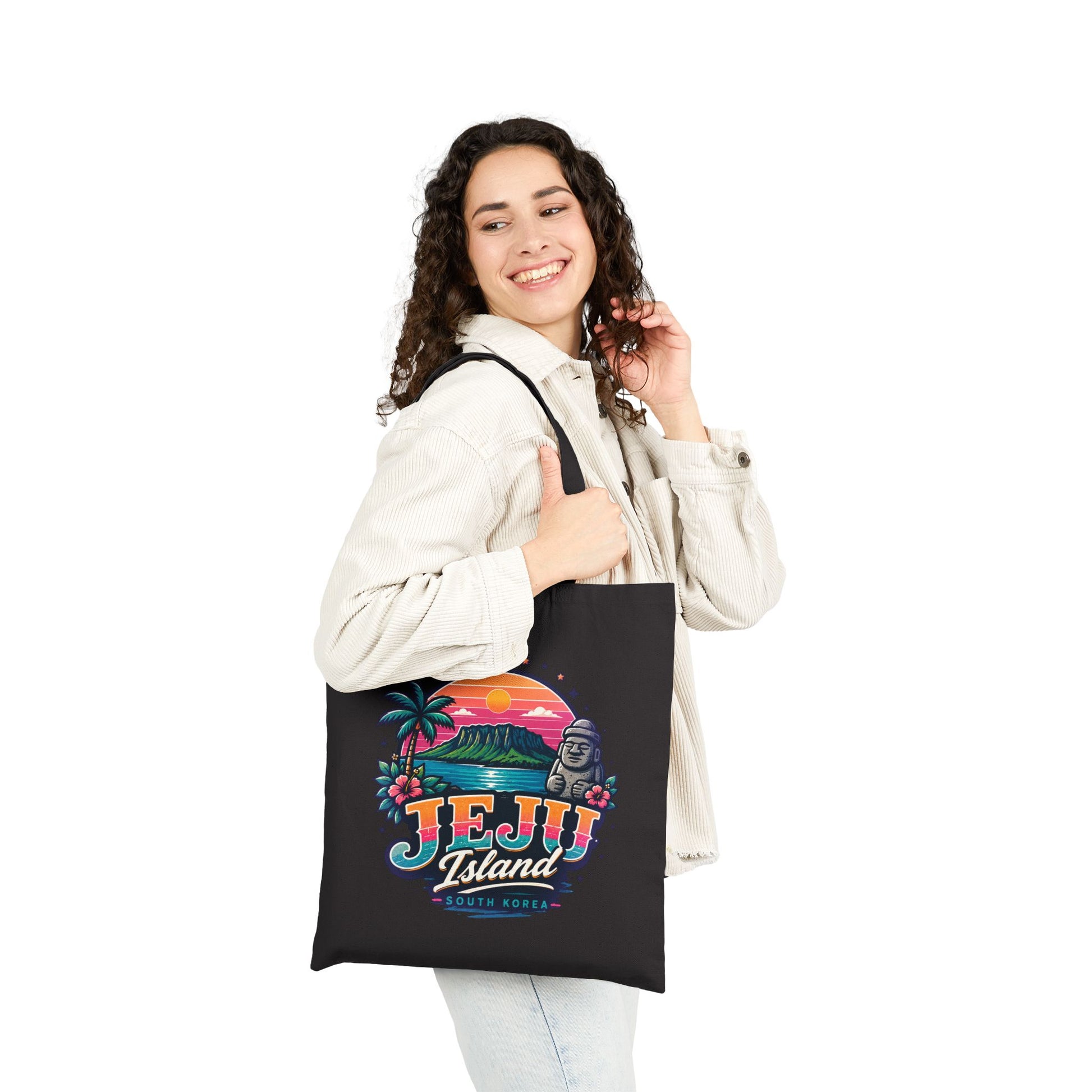 Black canvas tote bag worn in front, featuring colorful Jeju Island graphic