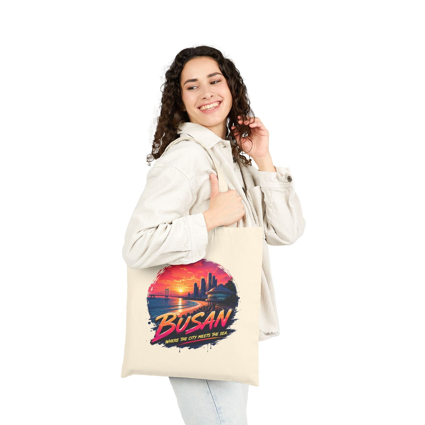 Natural canvas tote bag worn on shoulder with front sunset graphic