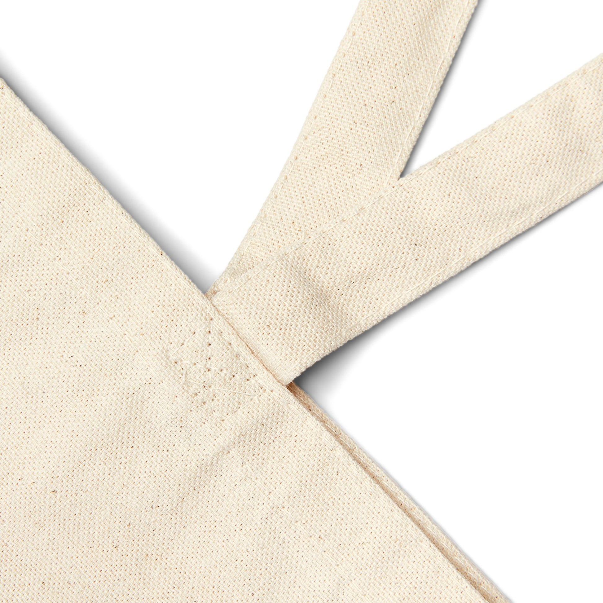 Natural canvas tote bag close-up of stitched handle and strap