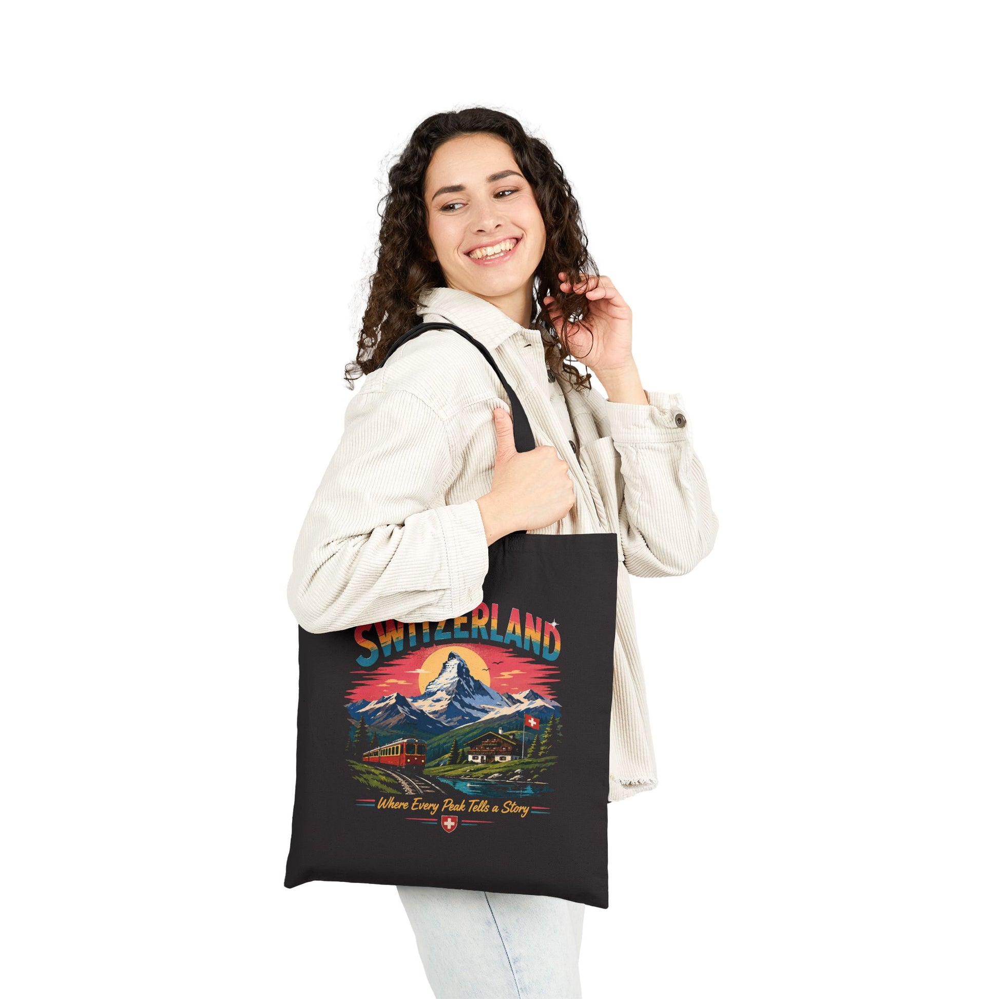 Black canvas tote bag with Switzerland graphic on front, worn by model.
