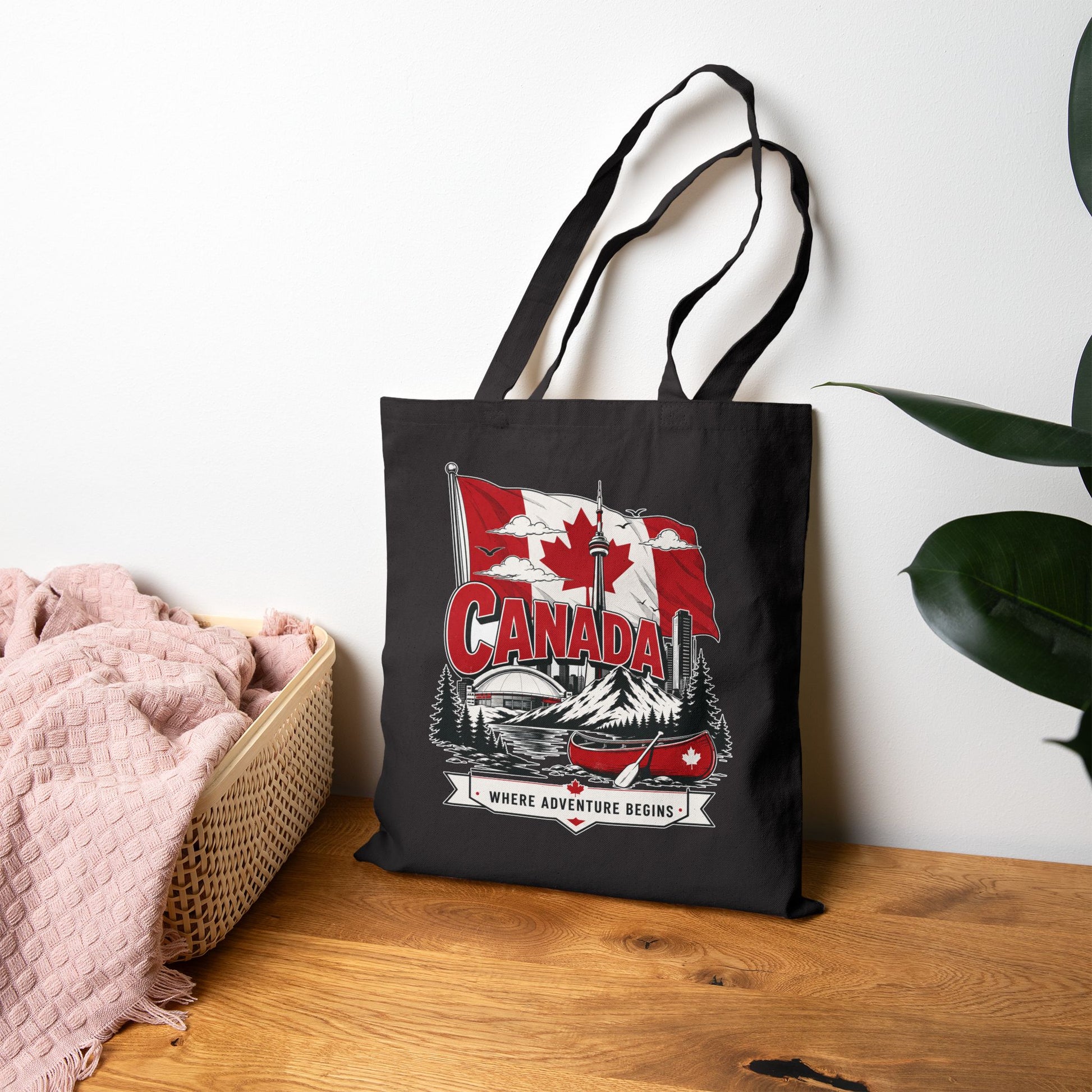 Black canvas tote bag with Canada flag canoe graphic and top handles