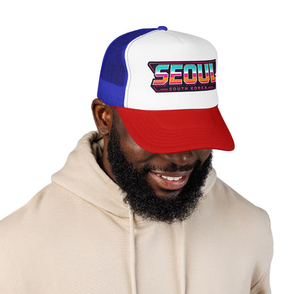 Blue and red trucker hat worn by man, front Seoul logo graphic