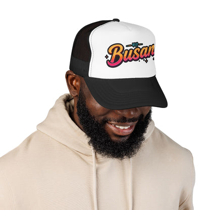 Two-tone trucker hat with white front and Busan logo, black mesh back, curved brim.