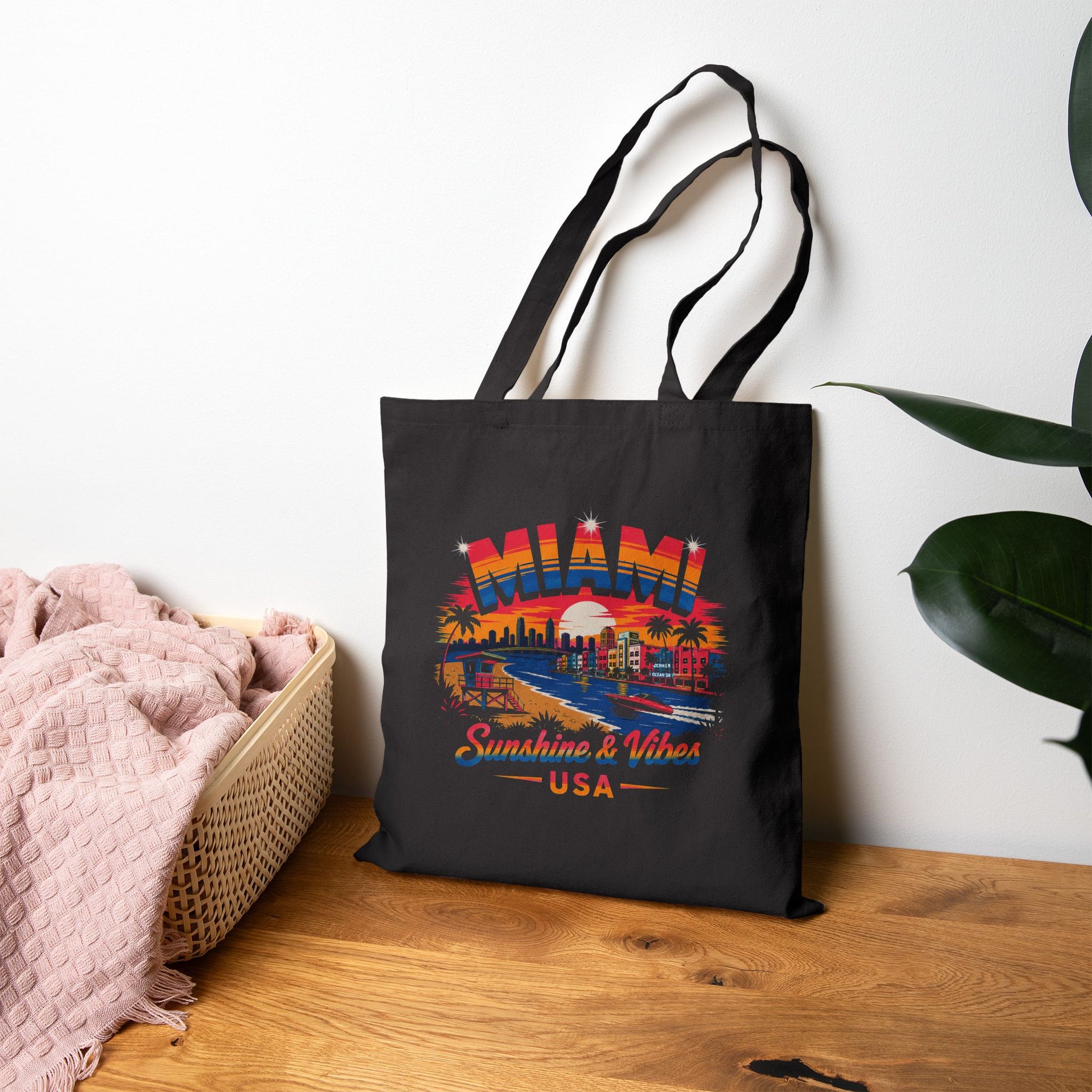 Black tote bag on wooden floor with Miami skyline graphic and two loop handles