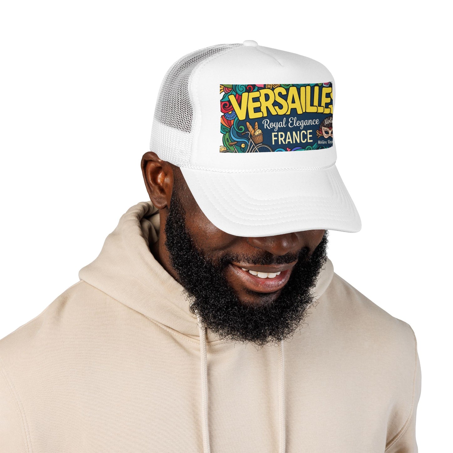 White trucker hat worn with a hoodie; front panel features “VERSAILLES” France patch.