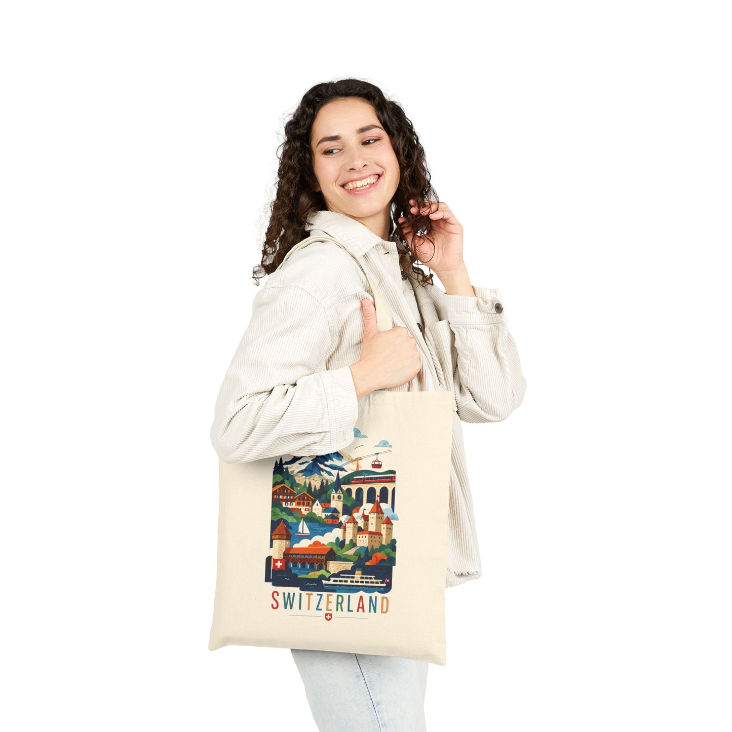 Natural canvas tote bag with Switzerland scenic artwork and red “SWITZERLAND” text, worn by a woman.