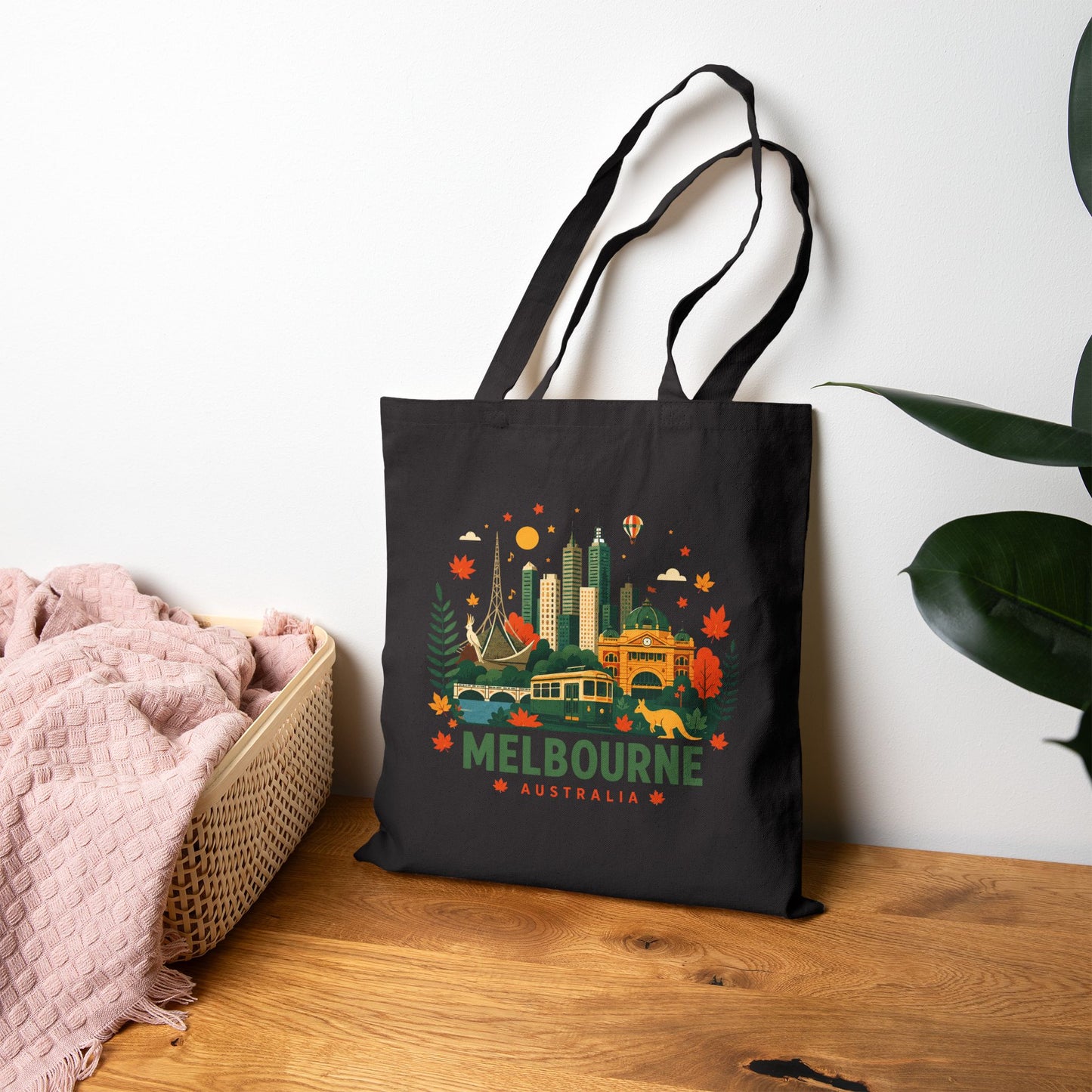 Black canvas tote bag with colorful Melbourne skyline graphic and handles