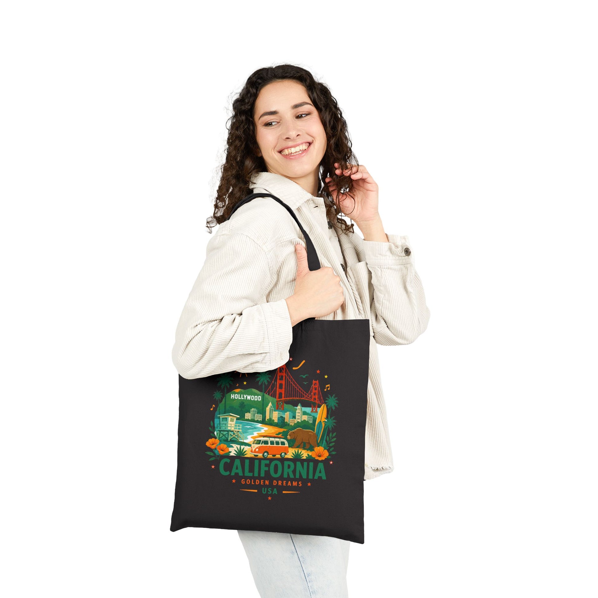 Black canvas tote bag worn by person with California graphic on front