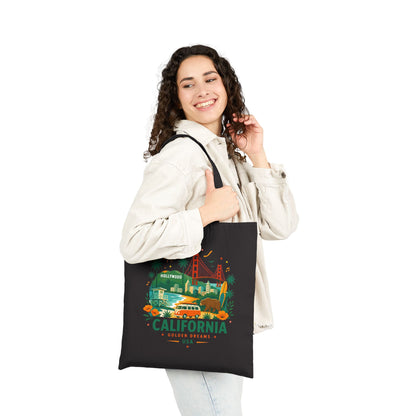 Black canvas tote bag worn by person with California graphic on front