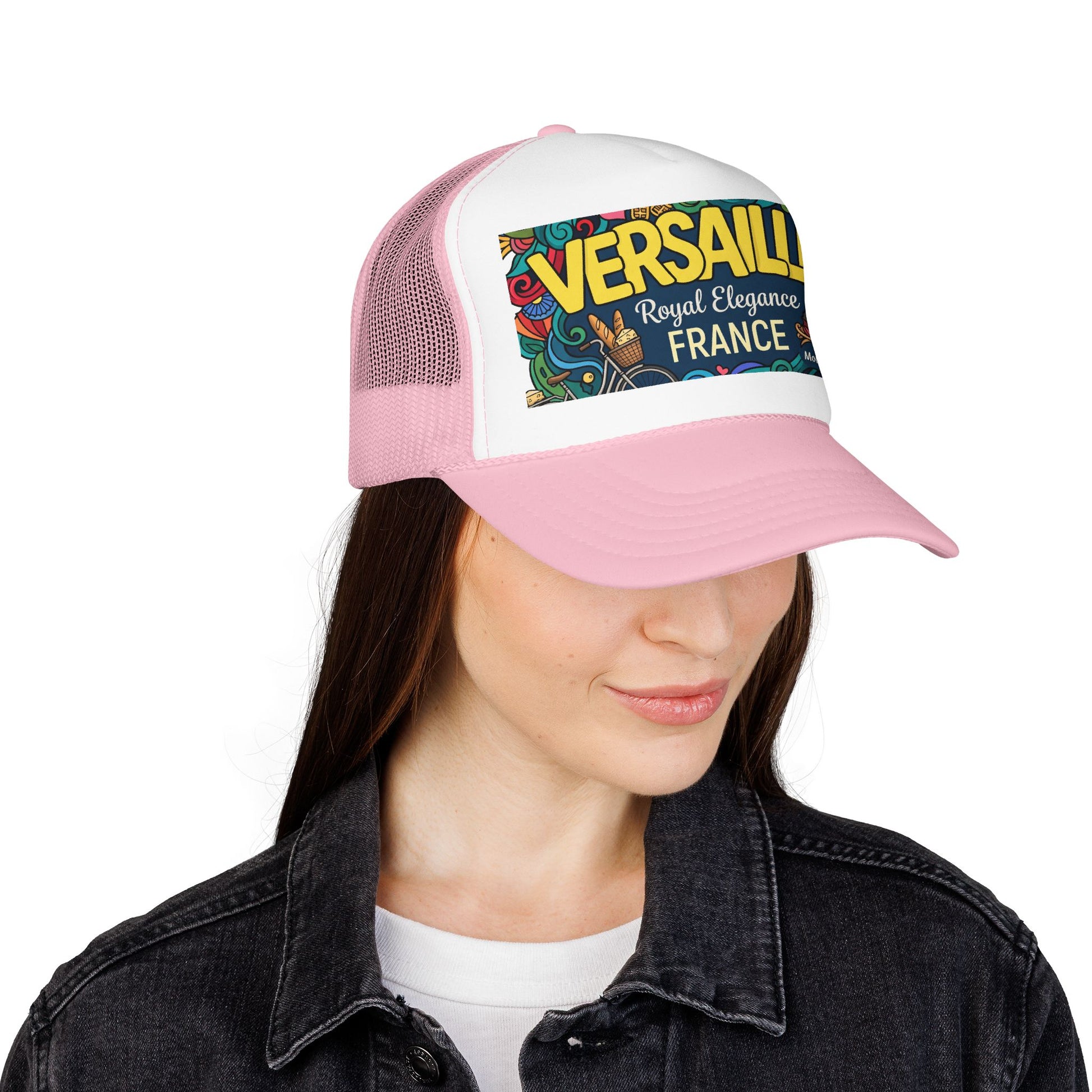 Pink-and-white trucker hat worn by a woman; “VERSAILLES” France graphic patch on front.