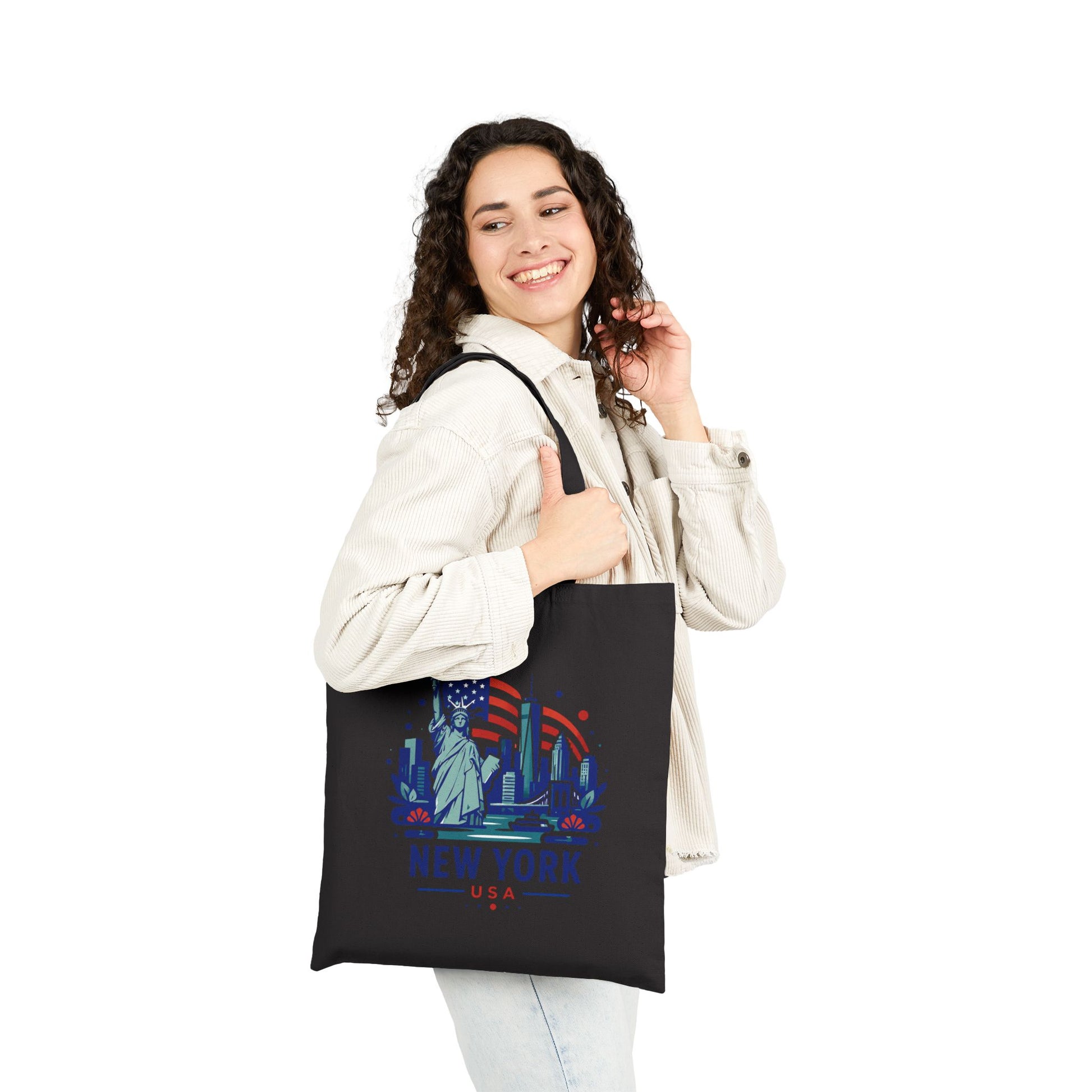 Black cotton canvas tote bag worn by person, with Statue of Liberty New York graphic