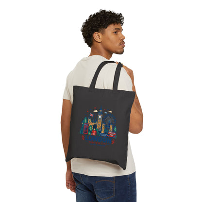 Black canvas tote bag worn on the shoulder, London skyline graphic on front