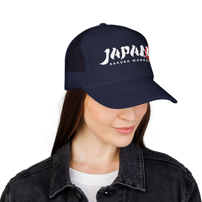 Dark navy trucker hat worn by a person, front logo visible above dark jacket.