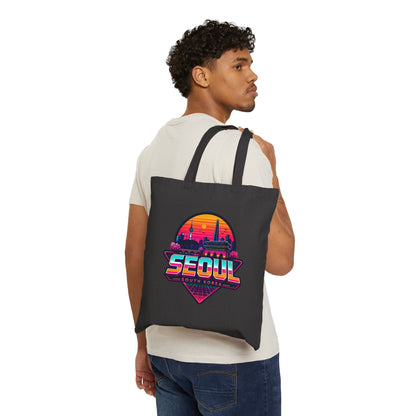 Black tote bag worn by model, front shows colorful Seoul skyline graphic.