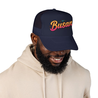 Navy trucker cap worn by man, embroidered Busan logo front