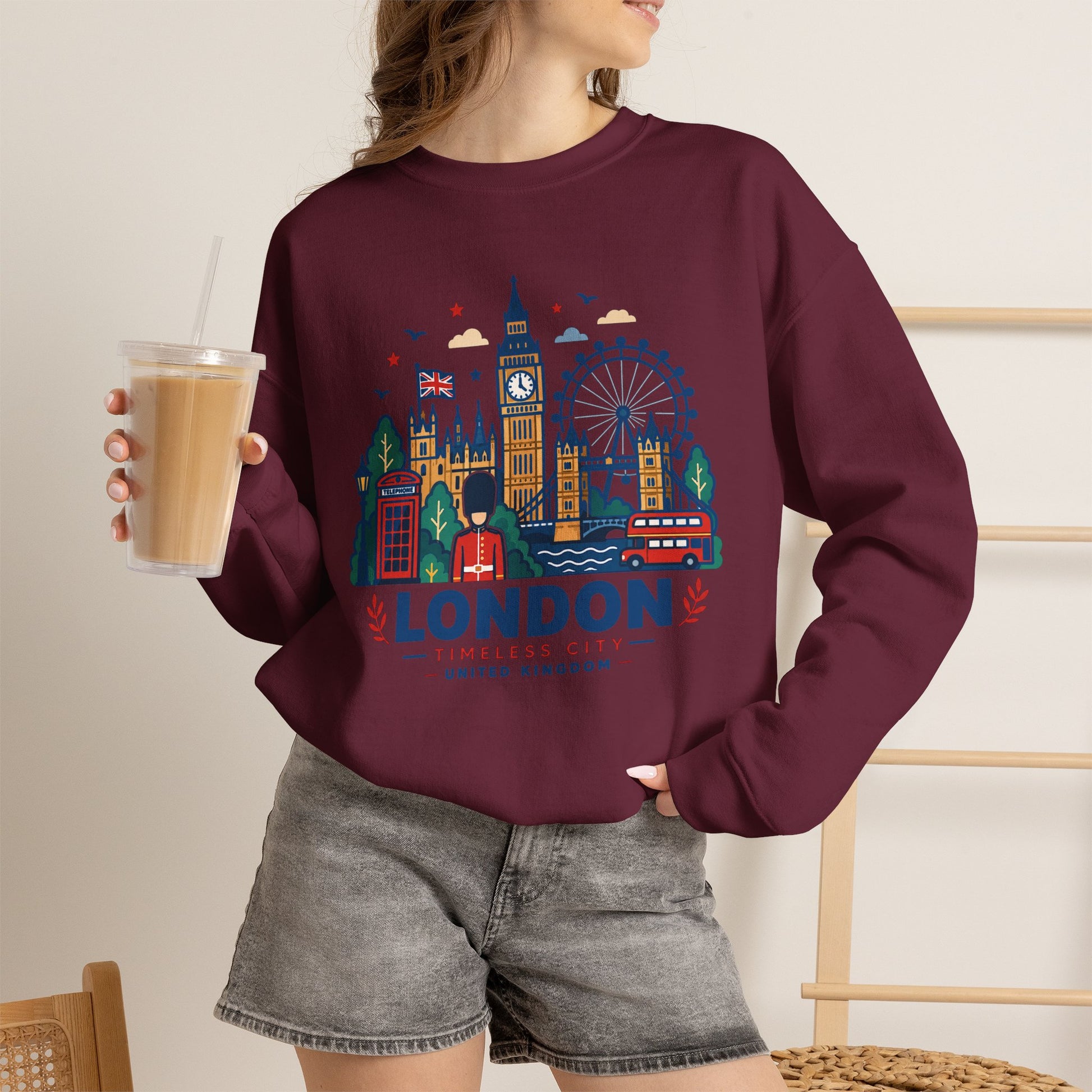 Maroon crewneck sweatshirt with London skyline graphic, person wearing