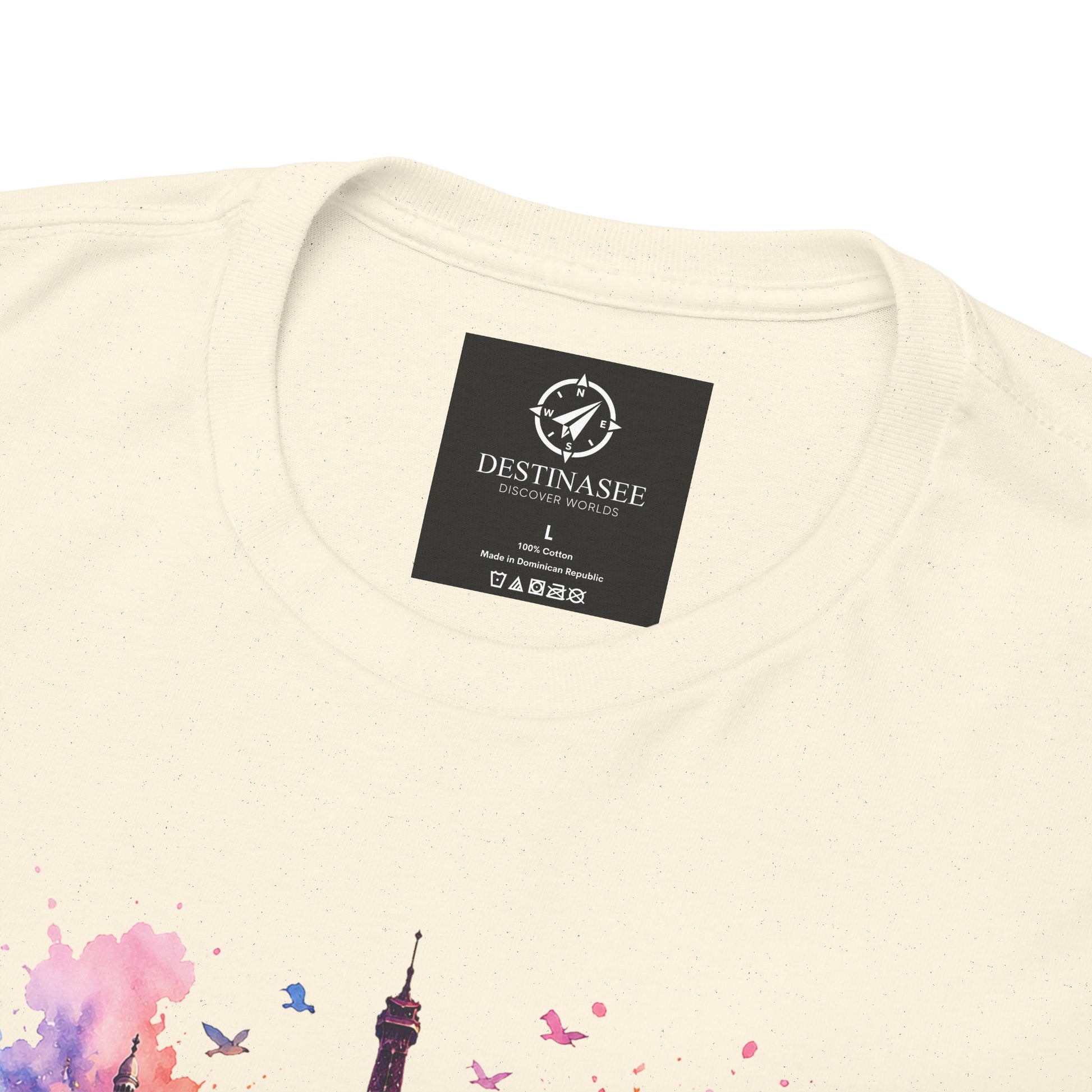 Cream T-shirt close-up showing woven neck label and partial floral Eiffel Tower artwork