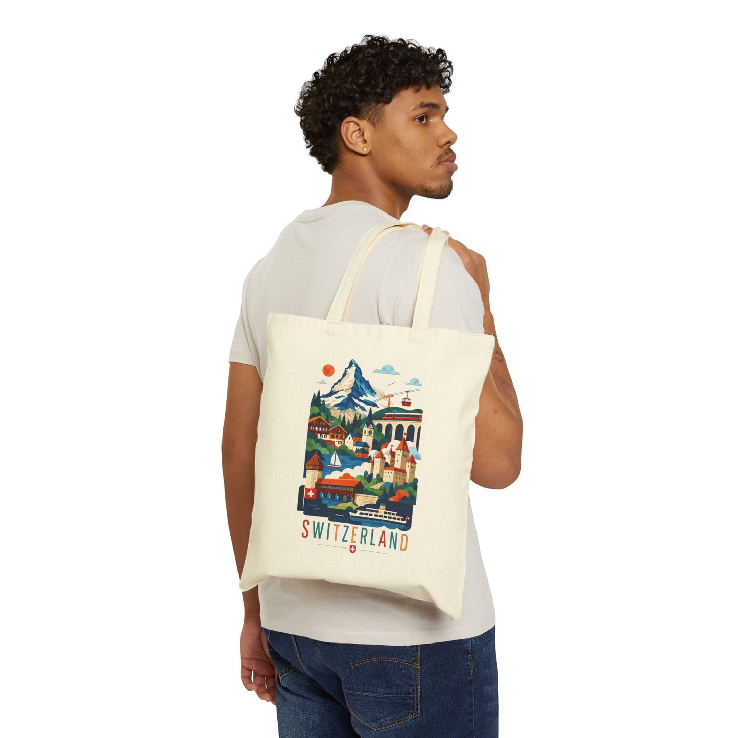 Natural canvas tote bag with Switzerland scenic print, carried on a man’s shoulder.