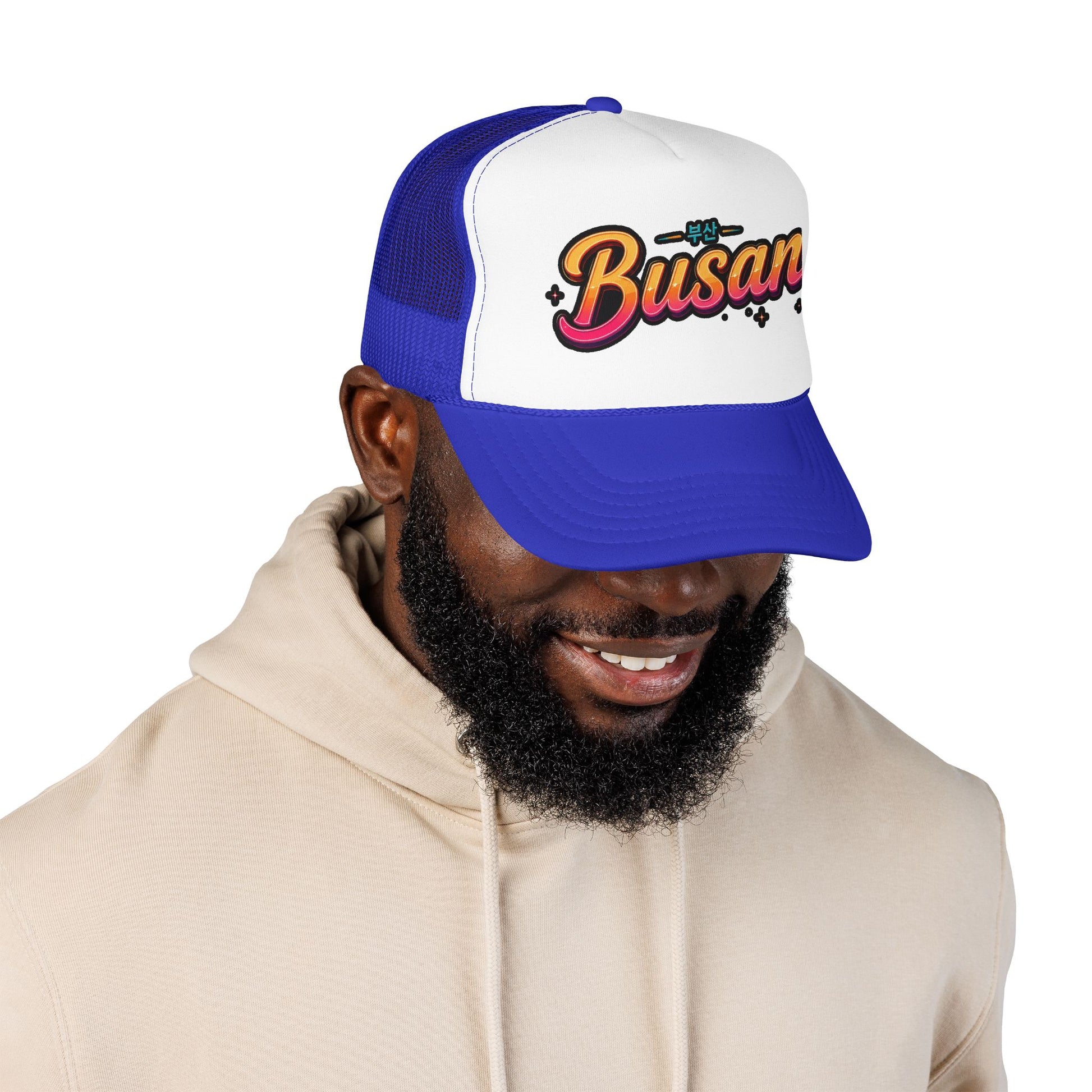 Blue and white trucker hat on model, front “Busan” logo embroidery