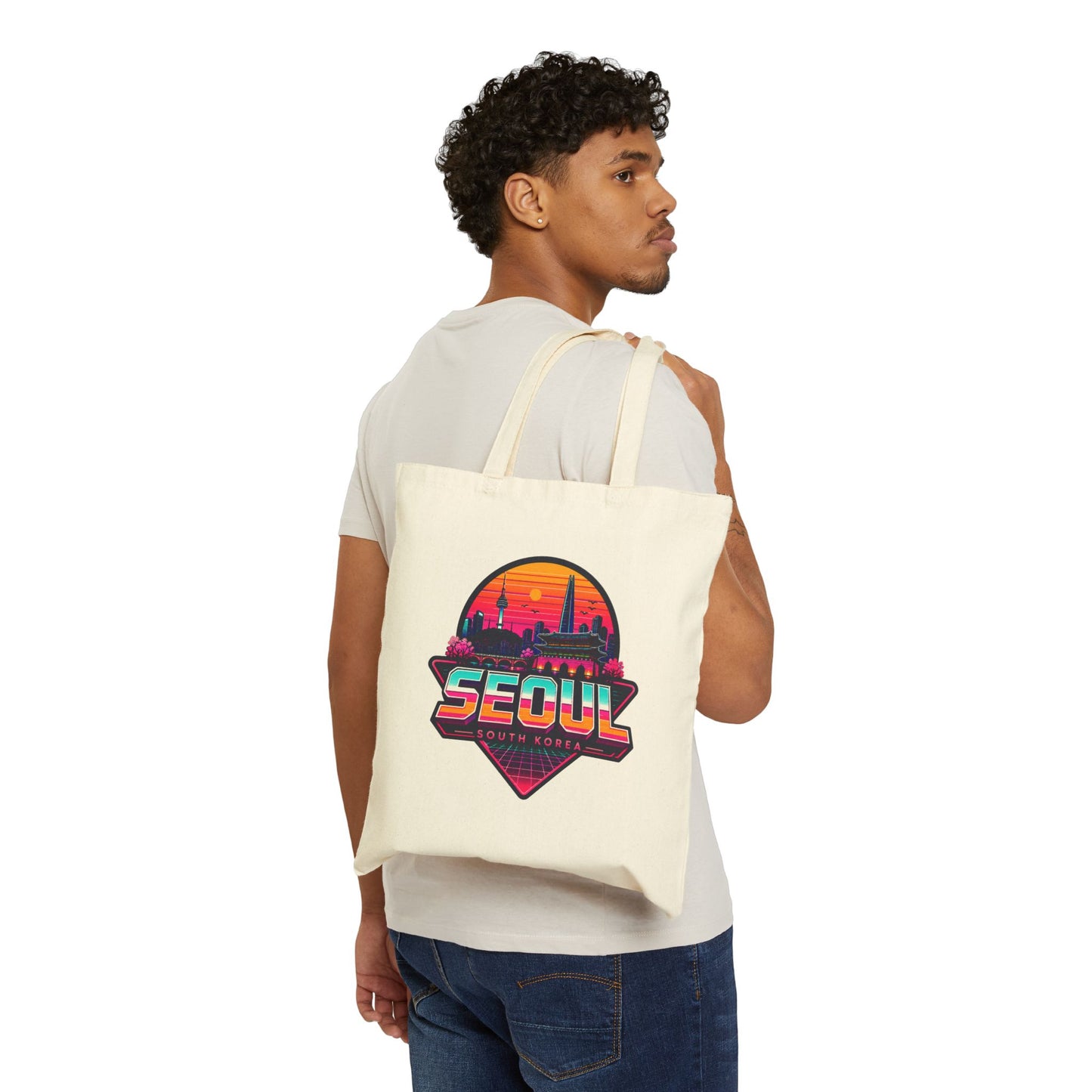 Natural tote bag worn by model, colorful Seoul skyline graphic on front.