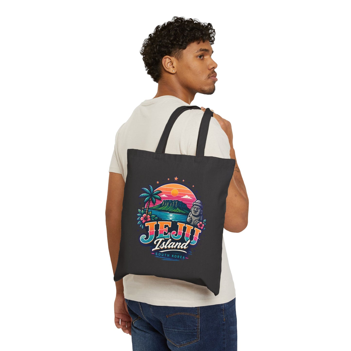 Black canvas tote bag worn on back, featuring colorful Jeju Island front print
