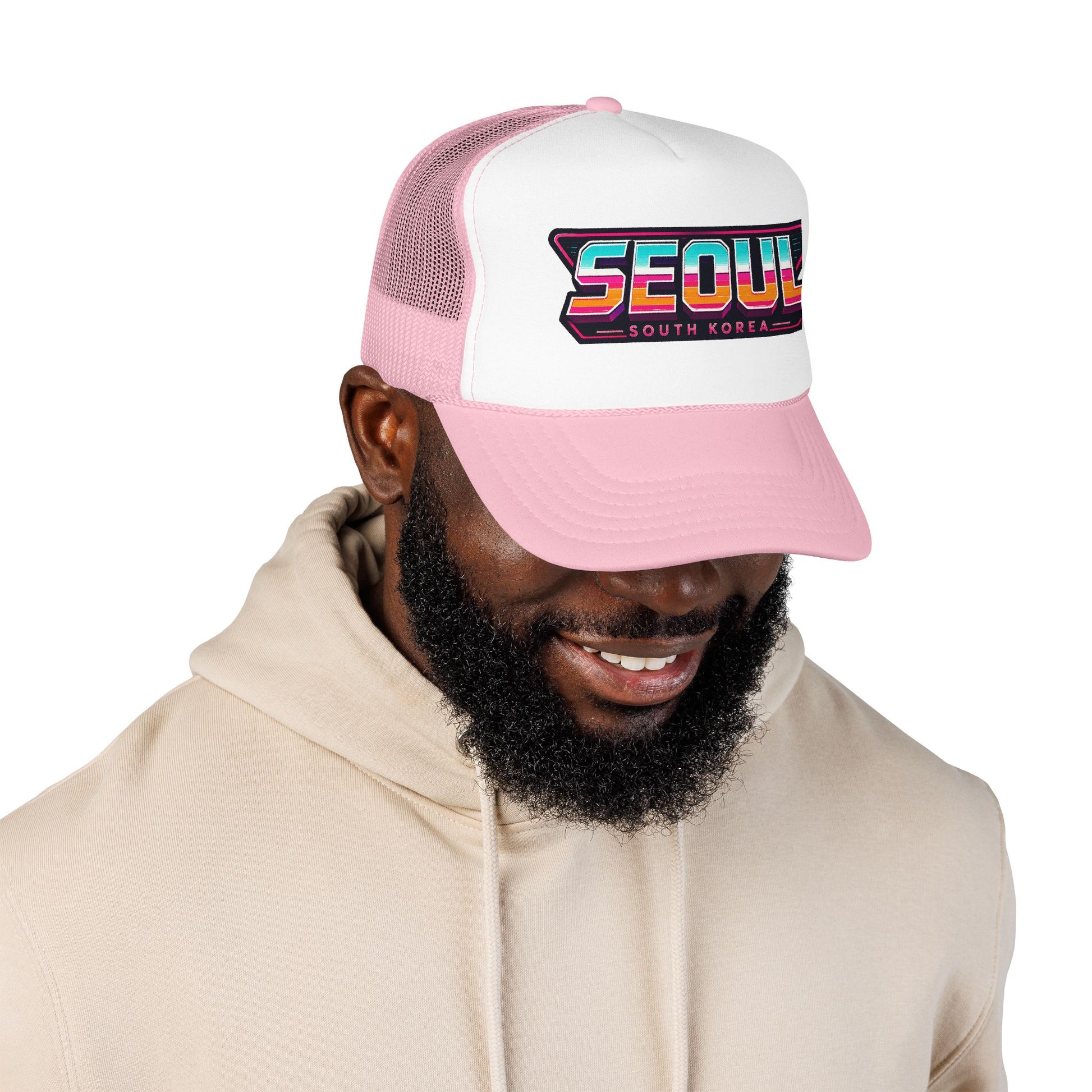 Pink and white trucker hat with “SEOUL SOUTH KOREA” front logo patch on mesh panel.