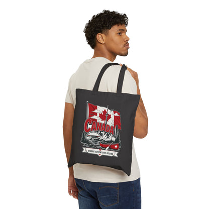 Black canvas tote bag worn on back with Canada flag canoe graphic