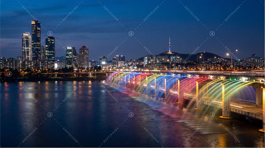 Rainbow-lit bridge and fountain skyline desktop wallpaper print with city lights over water