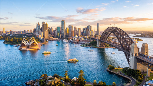 City skyline desktop wallpaper with harbor water, boats, and arched bridge at dusk